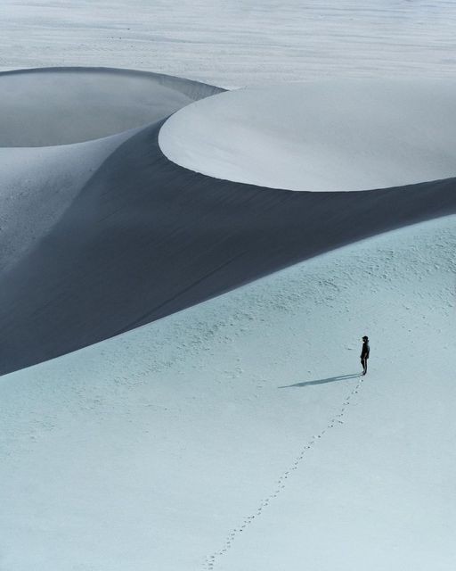 Paisagem de dunas com uma figura solitária ao longe